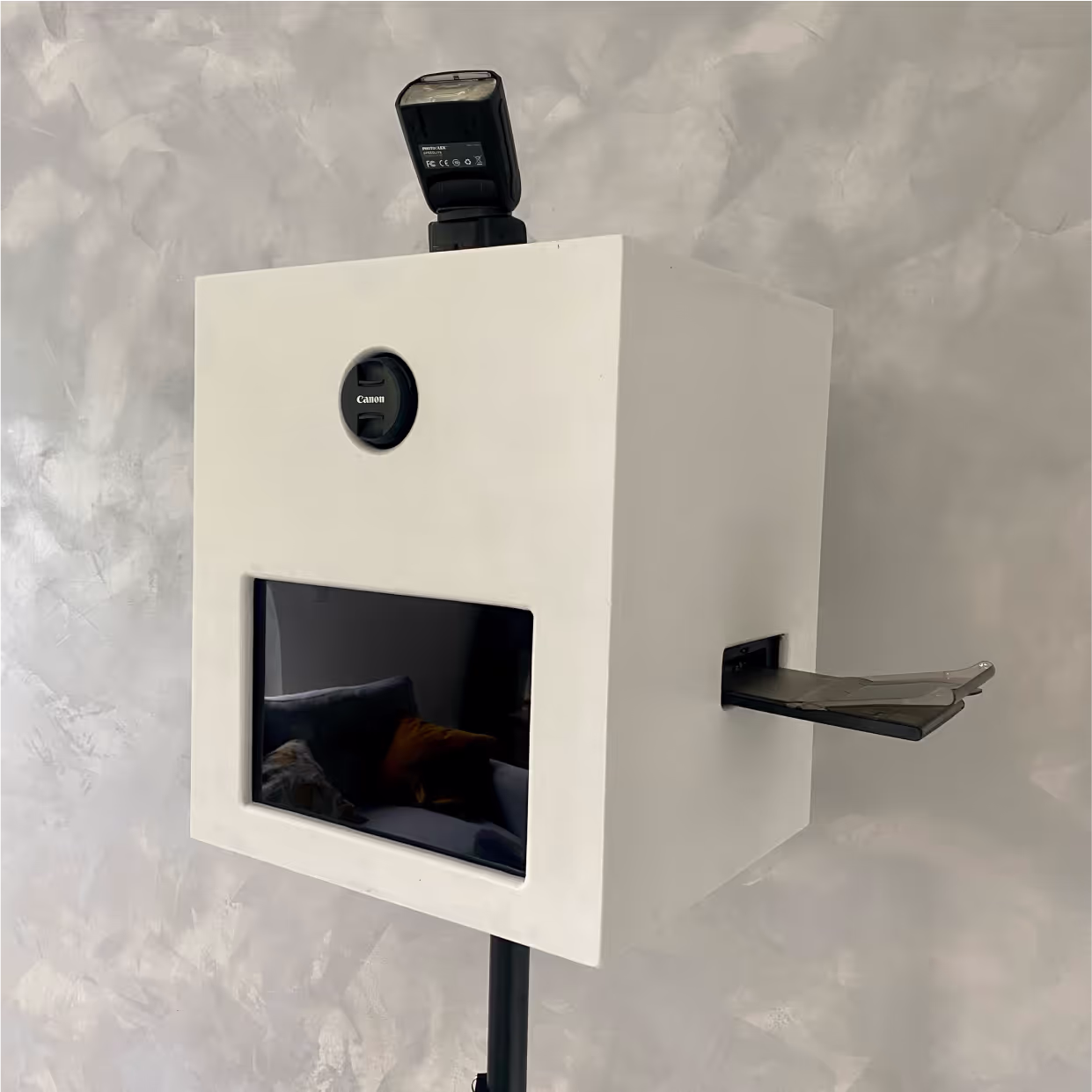 Eine Fotobox platziert vor einer grauen Wand
